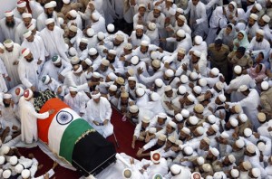 Indian Muslims stretch out their hands towards the body of the head of the Dawoodi Bohra Muslim community Syedna Mohammed Burhanuddin during his funeral procession in Mumbai, India, Saturday, Jan. 18, 2014. A pre-dawn stampede killed more than a dozen people Saturday as tens of thousands of people gathered to mourn the death of Muslim spiritual leader Burhanuddin in the India's financial capital, police said. Burhanuddin died Friday at the age of 102. (AP Photo/Rajanish Kakade)