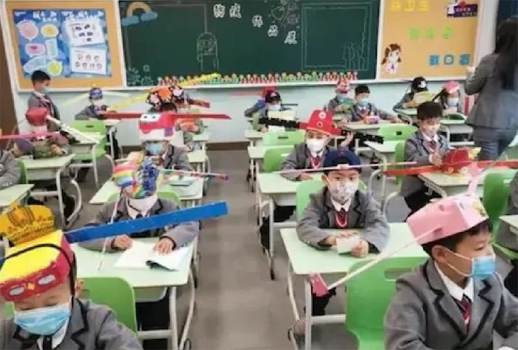 चीनी छात्र  सिर पर डंडे वाली टोपी लगाकर विद्यालय पहुँचे